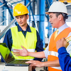 construction workers in front of a computer
