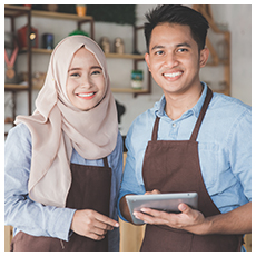 two business partner using tablet in front of their coffee shop. muslim entrepreneur concept
